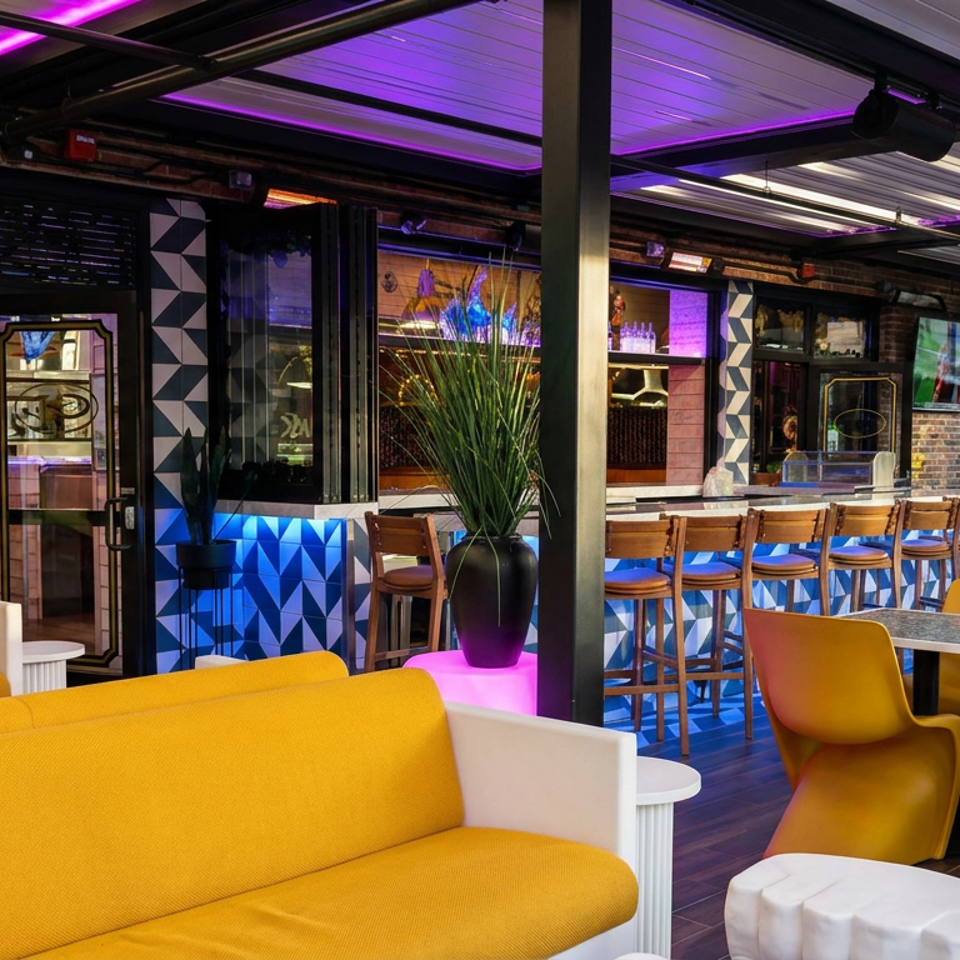 Modern restaurant lounge with yellow sofas, mustard chairs, bar seating, geometric décor, and purple accent lighting.